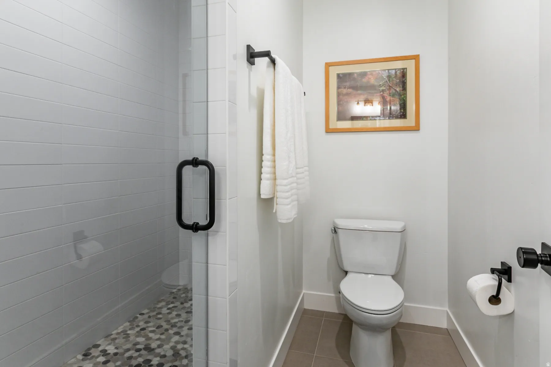 Full bath with a shower stall and light tile patterned flooring