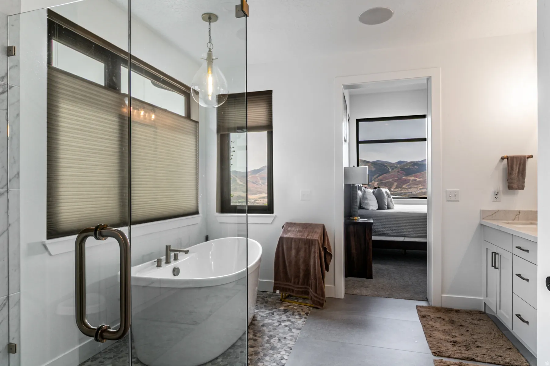 Bathroom featuring ensuite bath, a soaking tub, vanity, a stall shower, and concrete flooring