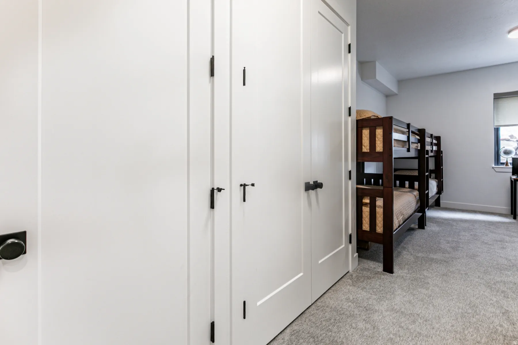 Hall featuring light colored carpet and baseboards