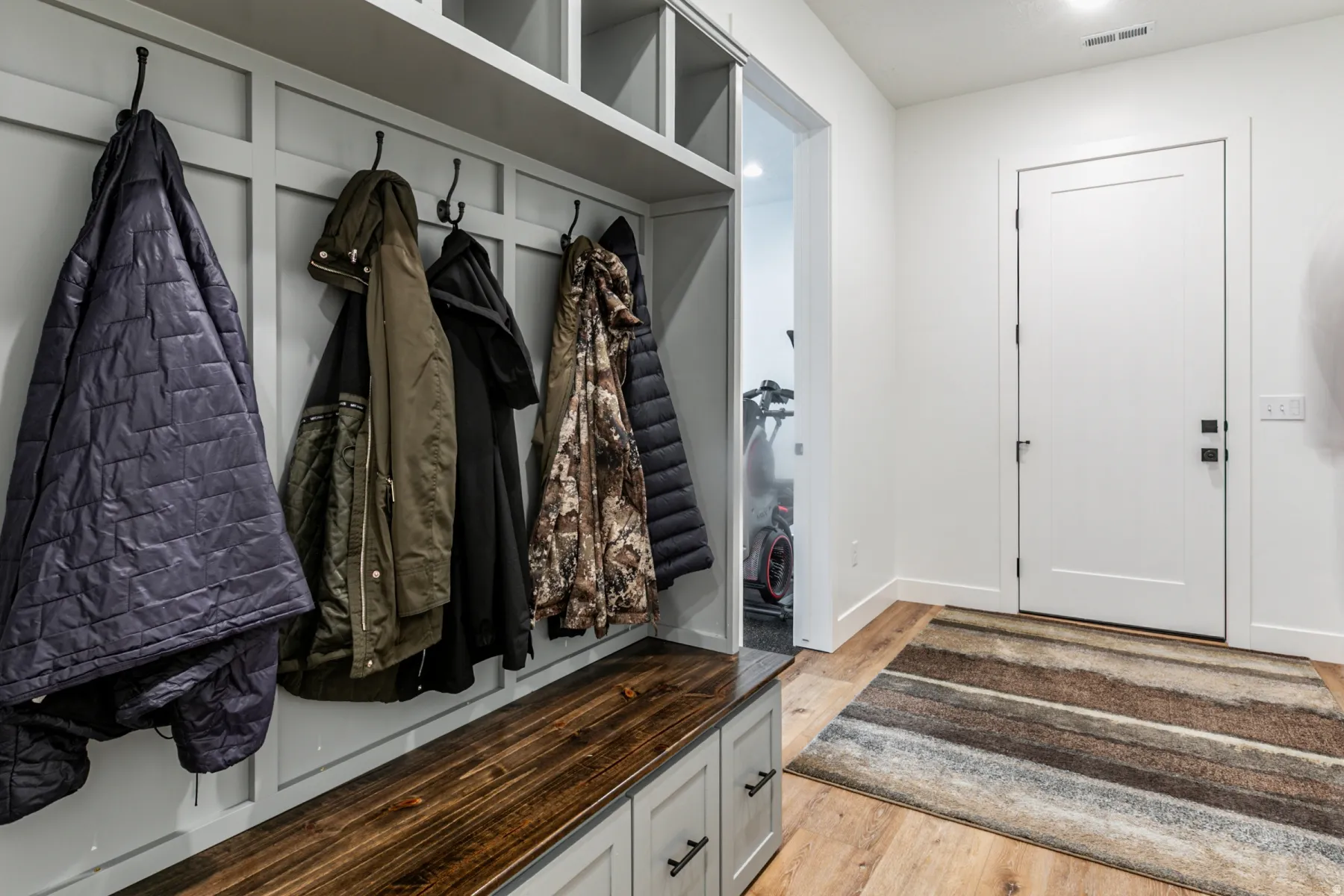 Mudroom with light wood-style floors and baseboards