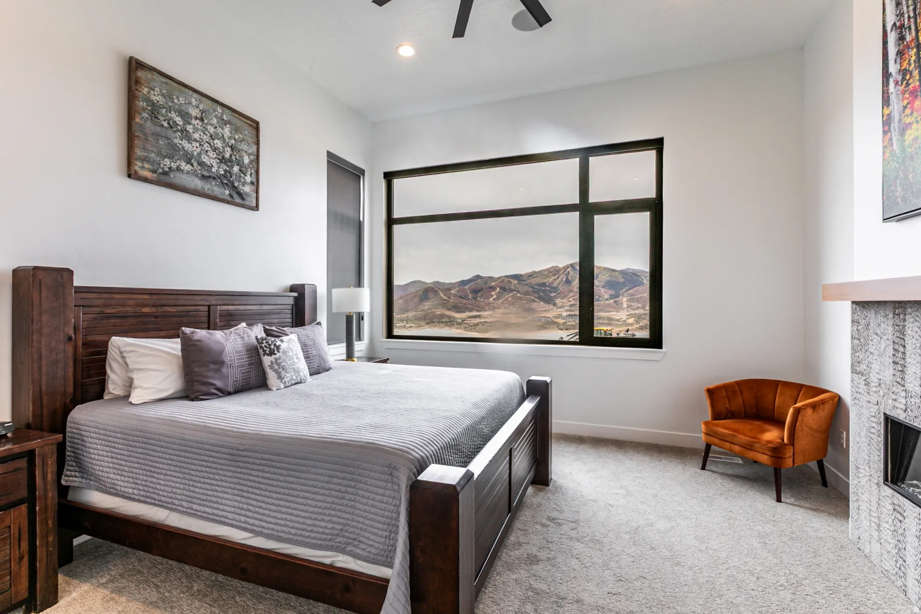 Bedroom with light carpet, ceiling fan, a fireplace, recessed lighting, and a mountain view