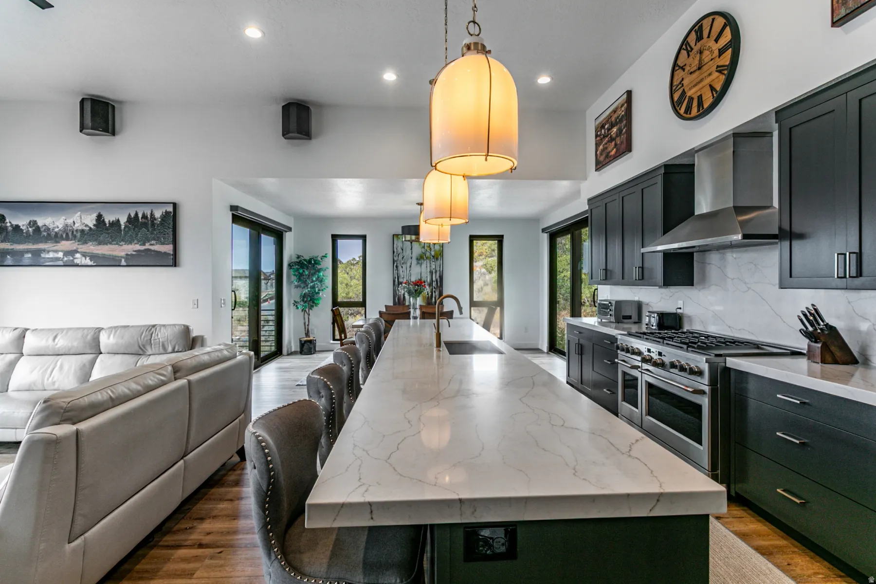 Kitchen with a breakfast bar area, light stone countertops, a spacious island, double oven range, and open floor plan