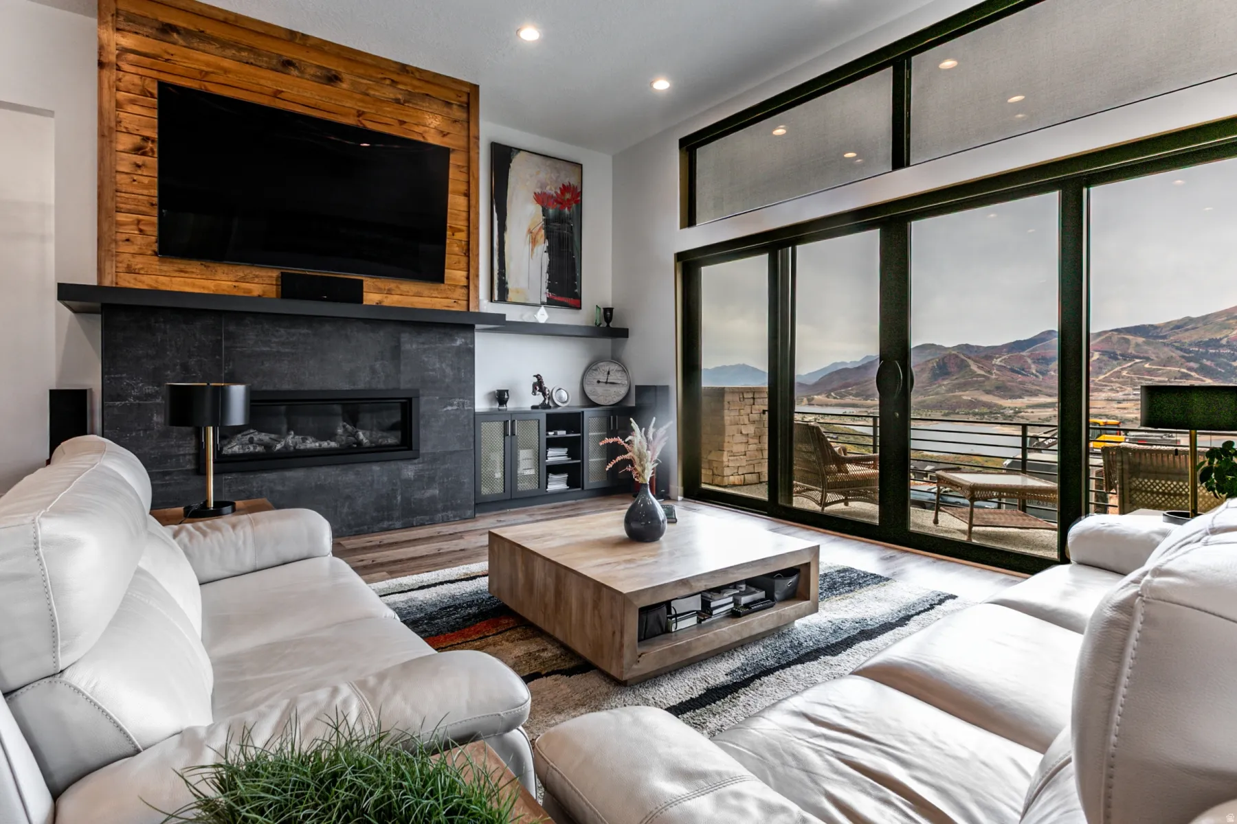 Living area featuring wood finished floors, recessed lighting, a tiled fireplace, and floor to ceiling windows