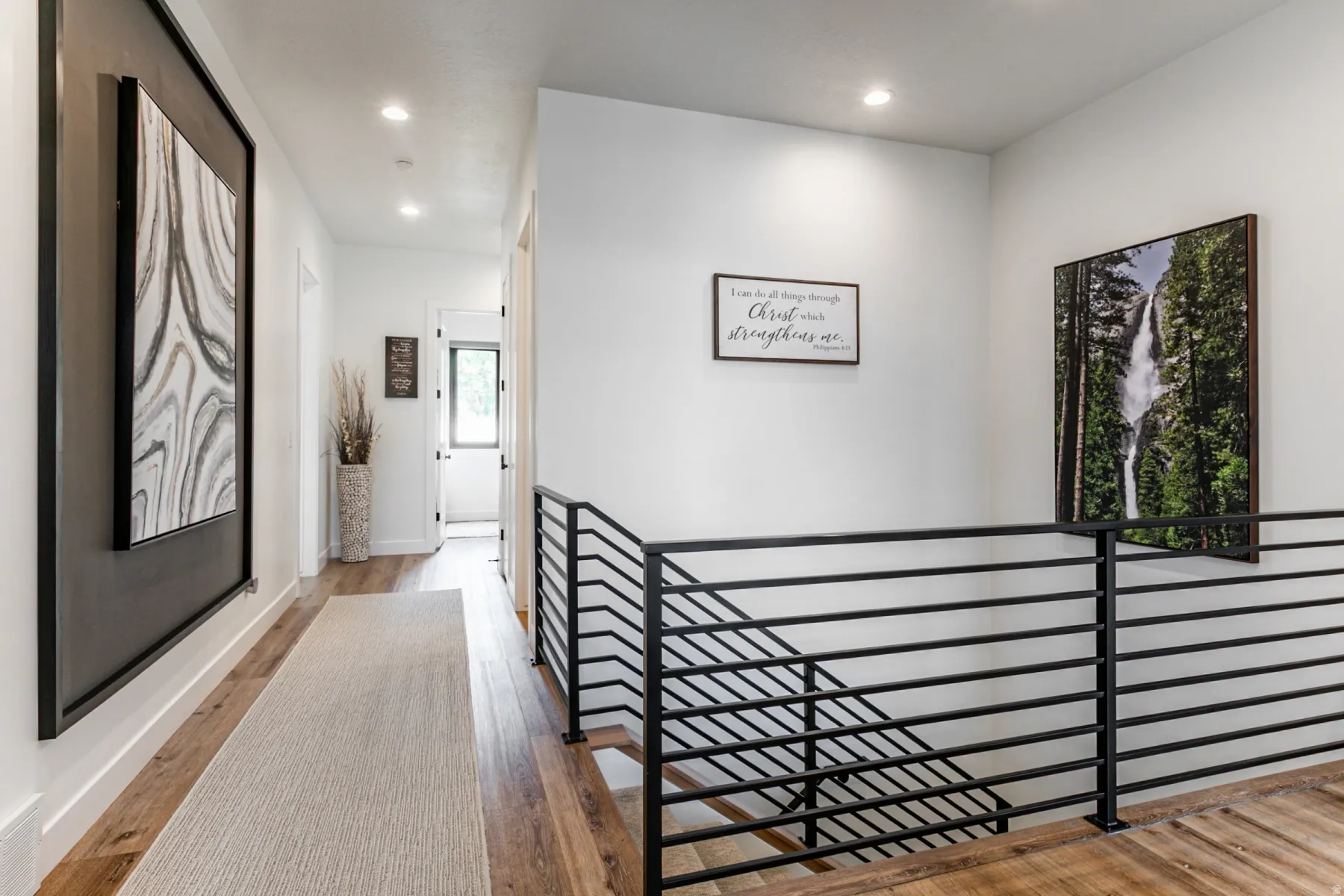 Hallway featuring an upstairs landing, light wood finished floors, and recessed lighting