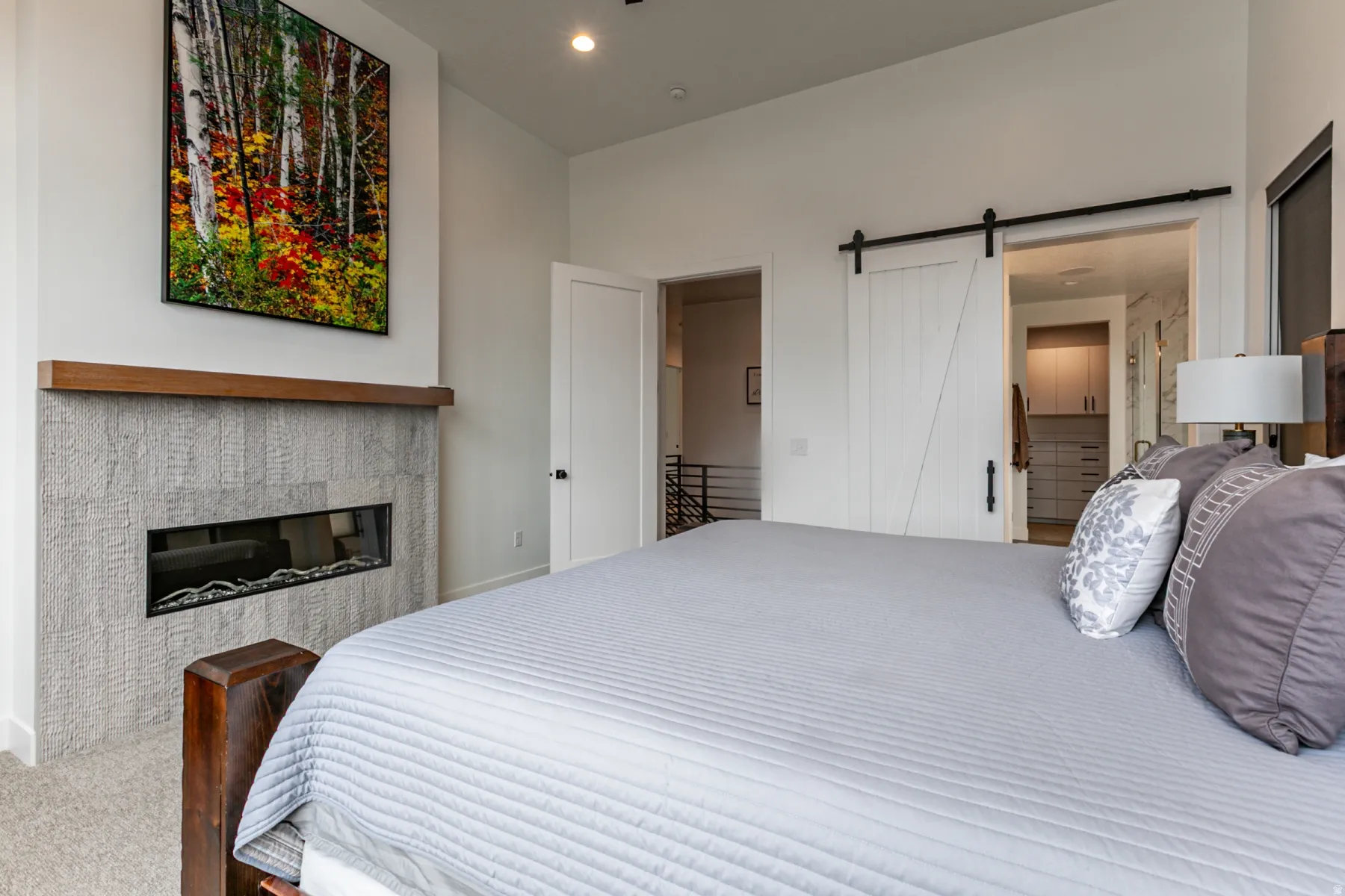 Carpeted bedroom featuring a barn door, connected bathroom, and recessed lighting