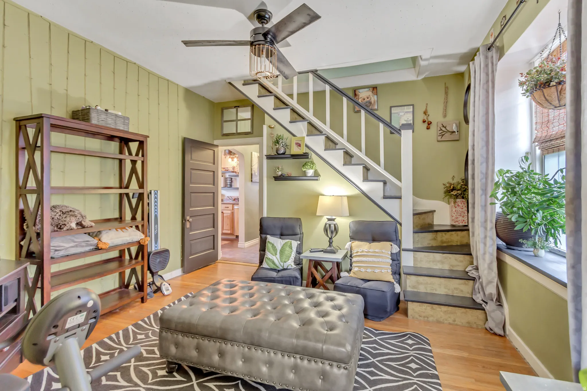 Sitting room with light wood-style floors and a ceiling fan