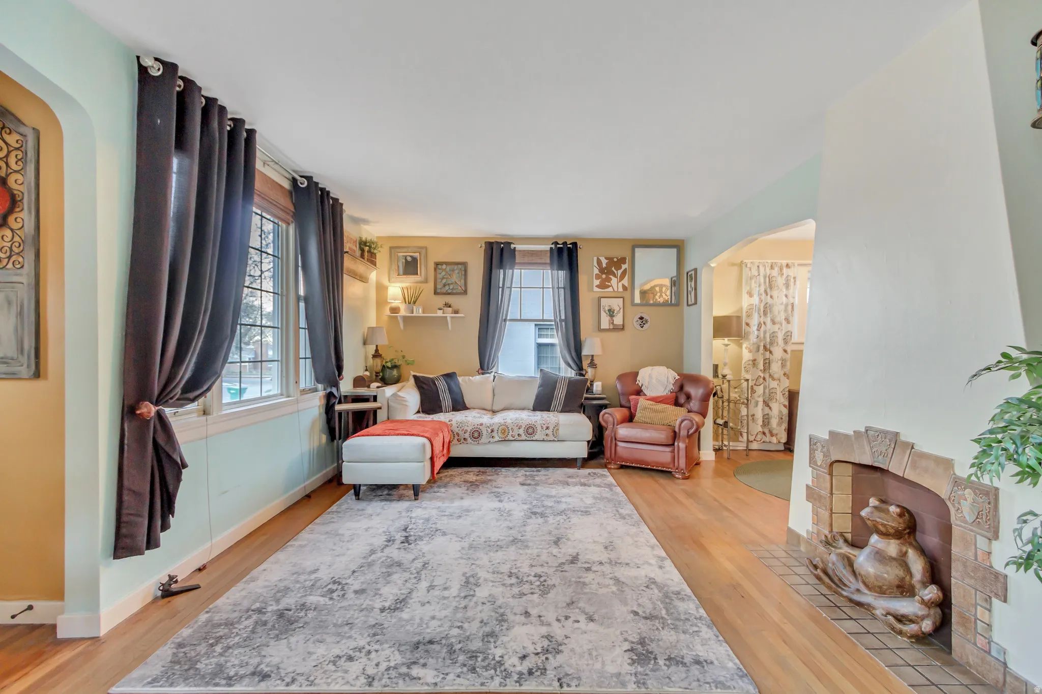 Living room with arched walkways and light wood-type flooring