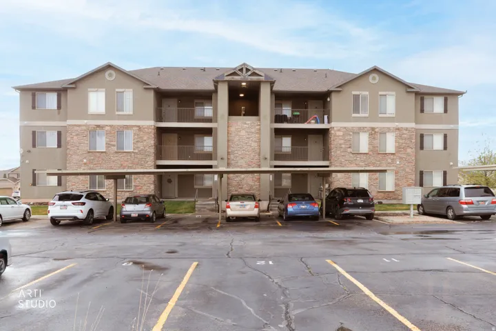 View of apartment building / complex with covered parking