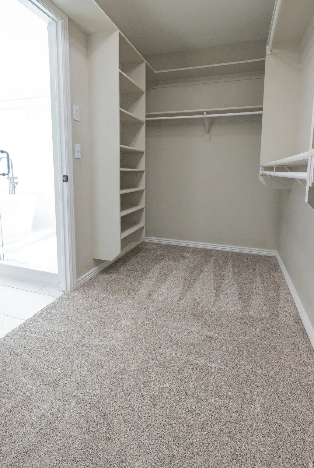 Walk in closet with light colored carpet