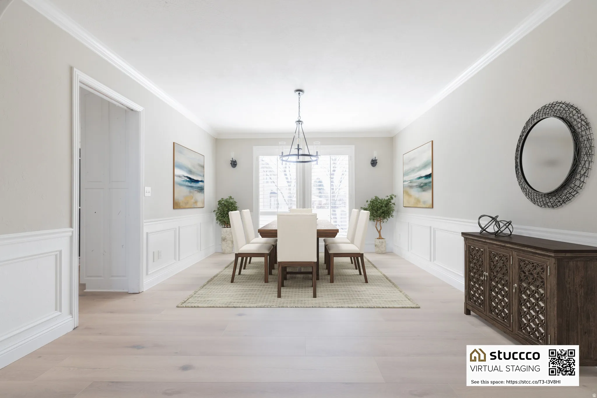 Dining area featuring a decorative wall, light wood-style floors, wainscoting, ornamental molding, and suspended lighting