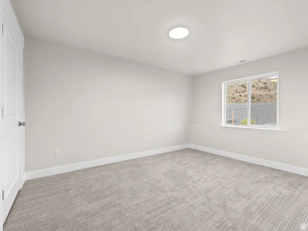 Carpeted empty room with baseboards