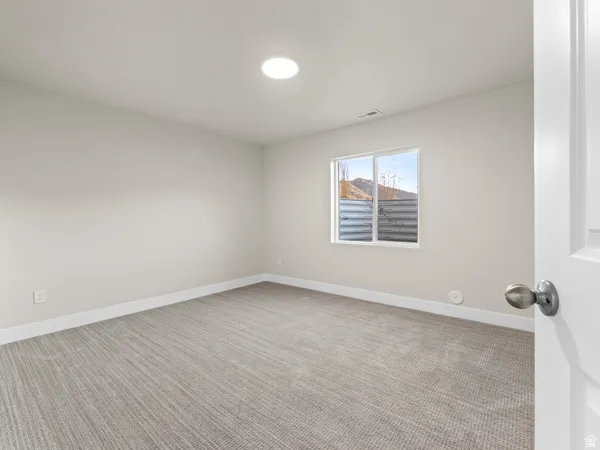 Spare room with light carpet and baseboards