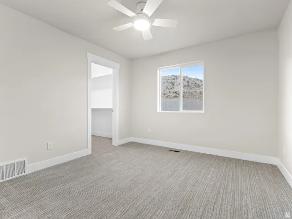 Unfurnished room featuring light carpet and ceiling fan