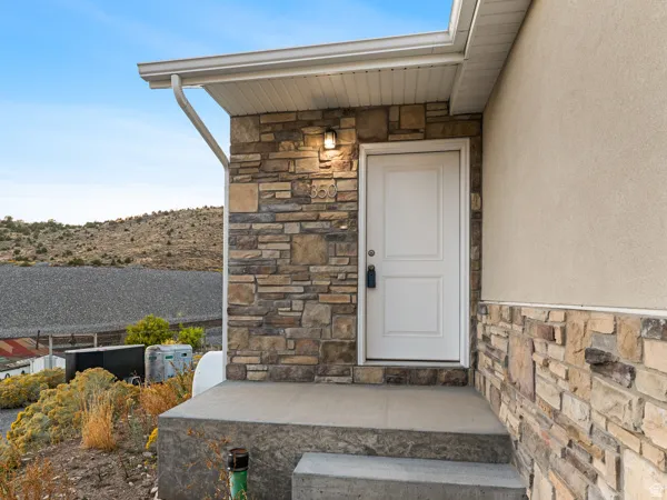 Property entrance with stone siding and stucco siding