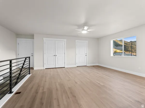 Unfurnished bedroom with light wood finished floors, a ceiling fan, and a closet