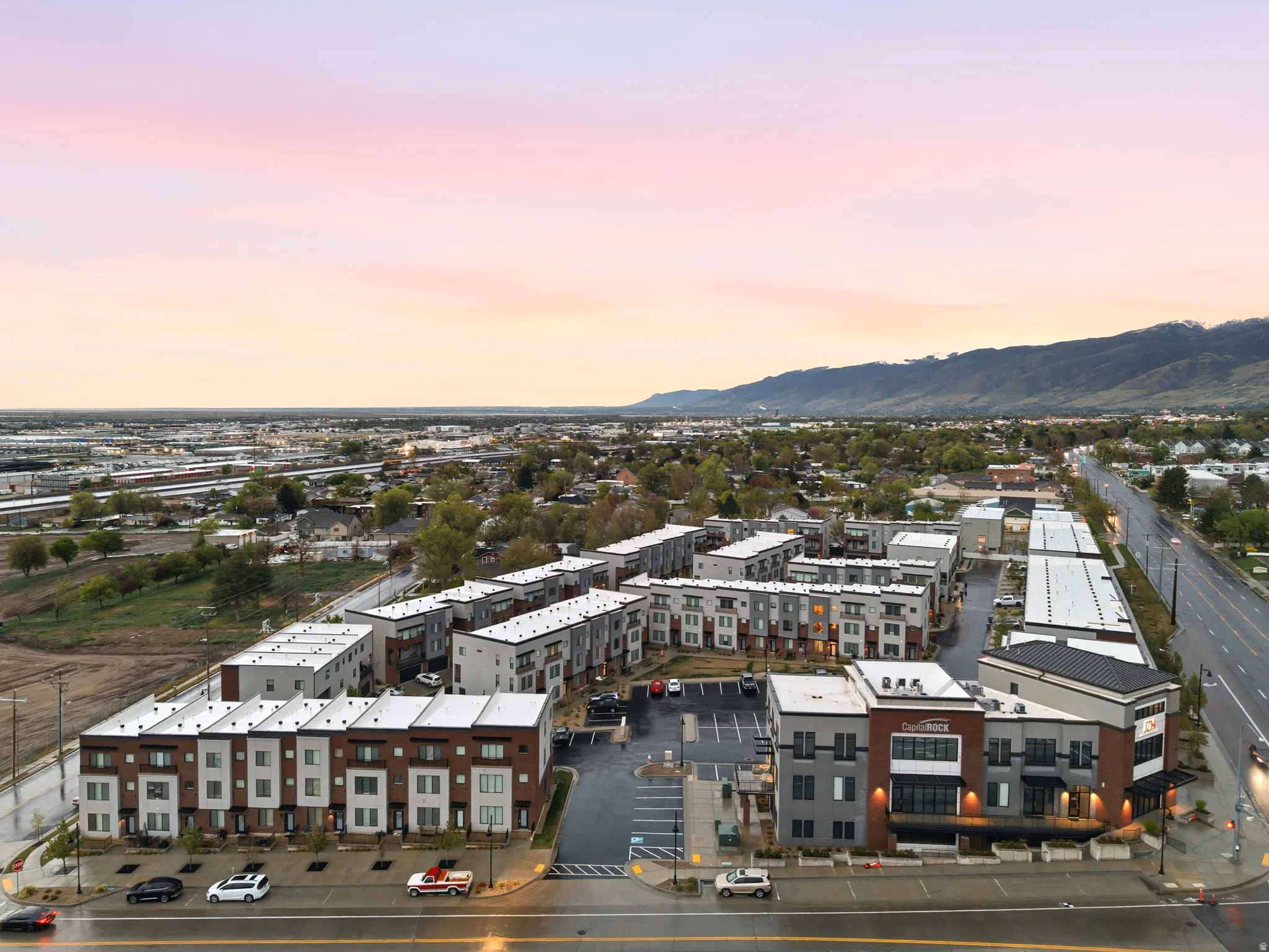 Aerial view at dusk of a view of apartment building / complex and a mountain view