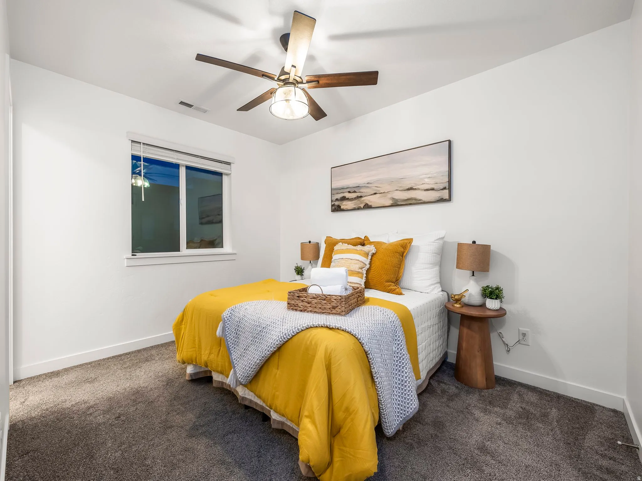 Bedroom with dark colored carpet and a ceiling fan