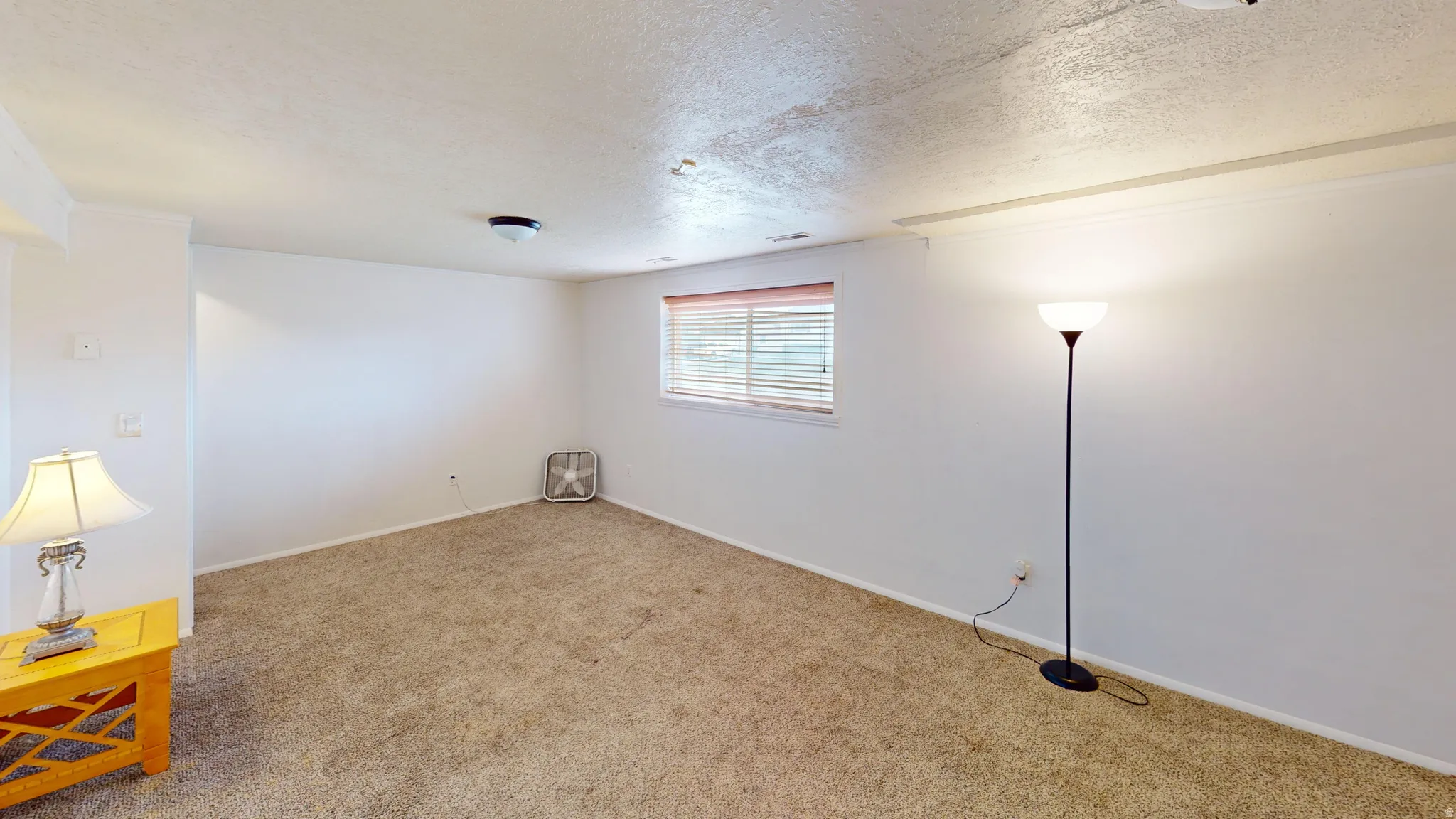 Unfurnished room with carpet flooring, a textured ceiling, and crown molding