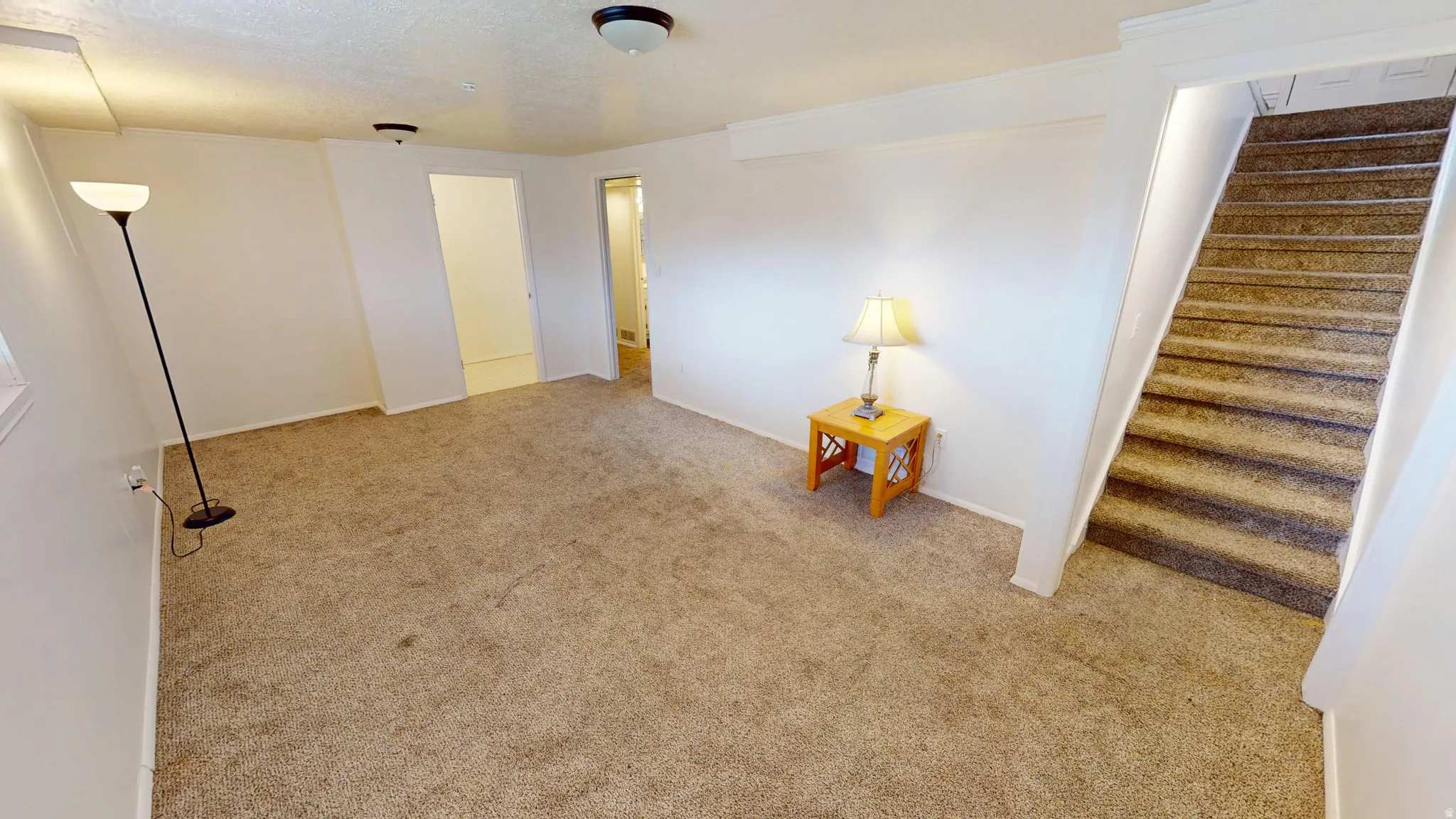 Unfurnished room with stairs and light colored carpet