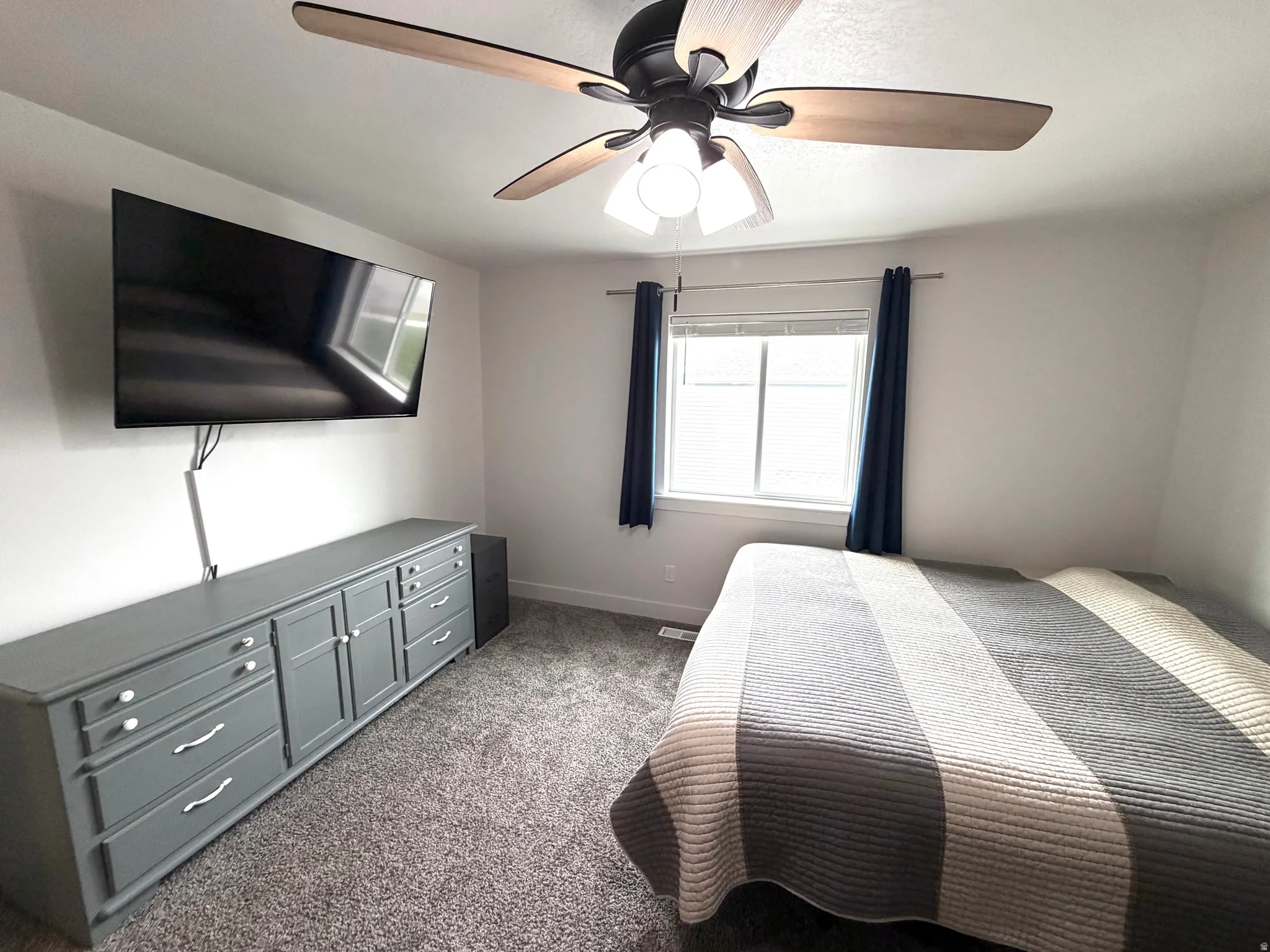 Bedroom with dark carpet and ceiling fan