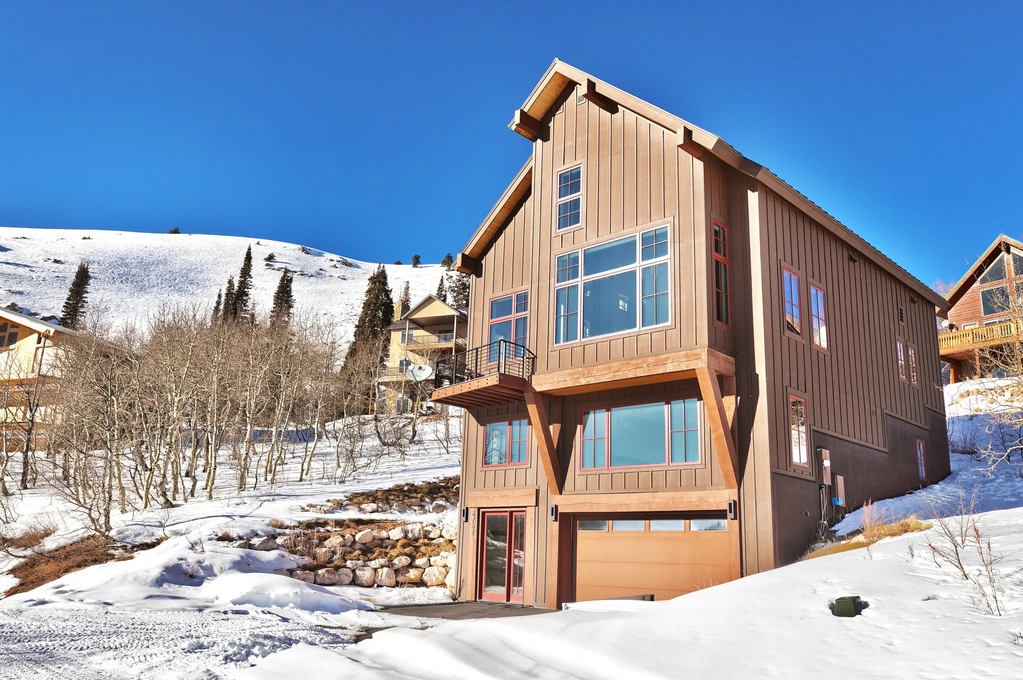 View of front facade featuring an attached garage, board and batten siding, a balcony, and a mountain view