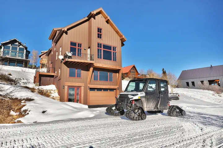 View of front of house featuring an attached garage and a balcony