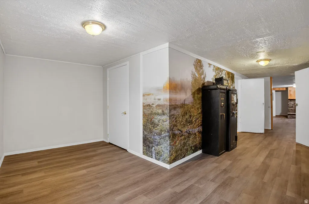 Hall featuring a textured ceiling and wood finished floors