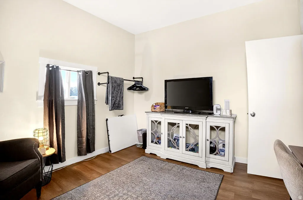 Living area featuring dark wood-style floors and baseboards