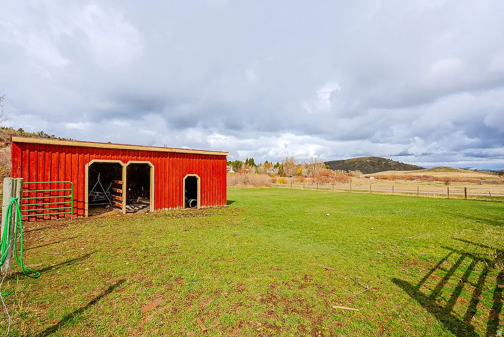View of yard featuring an outbuilding, a mountain view, and a view of rural / pastoral area