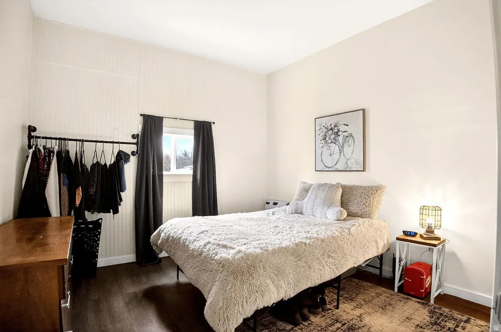 Bedroom featuring dark wood finished floors and baseboards