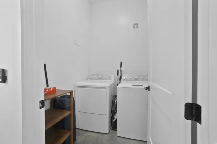 Laundry area with independent washer and dryer and concrete floors