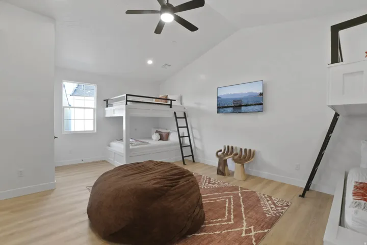 Bedroom with light wood-type flooring, lofted ceiling, ceiling fan, and recessed lighting