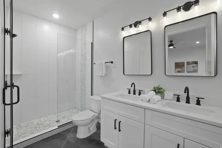 Full bathroom with a shower stall, double vanity, and recessed lighting