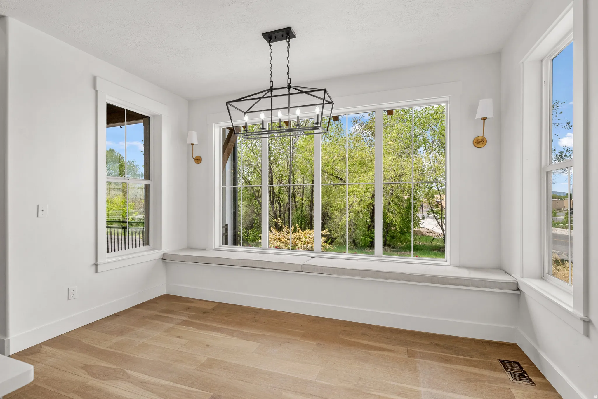 Unfurnished dining area featuring a chandelier and light wood-style floors