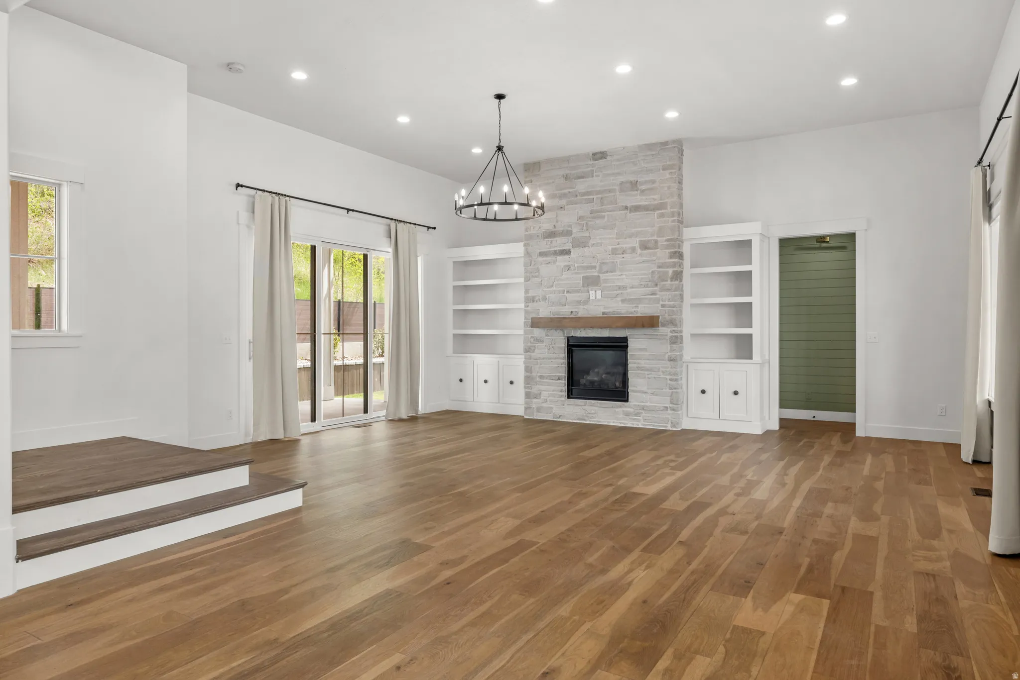 Unfurnished living room featuring dark wood-type flooring, a chandelier, and a fireplace
