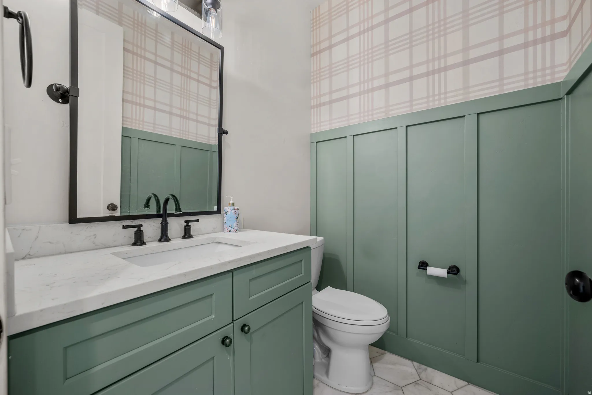 Bathroom featuring vanity, a decorative wall, and wallpapered walls