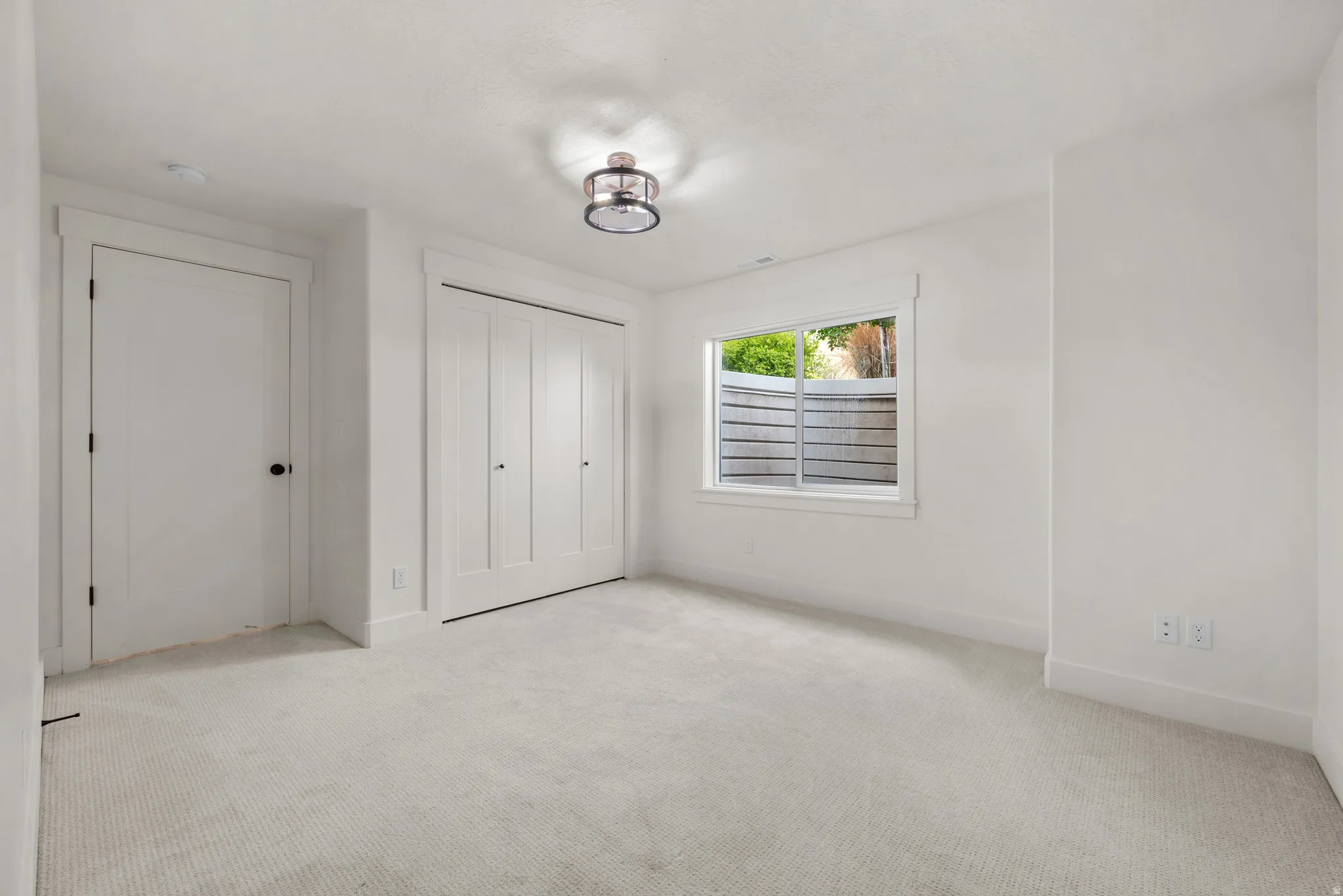 Unfurnished bedroom featuring light carpet and a closet