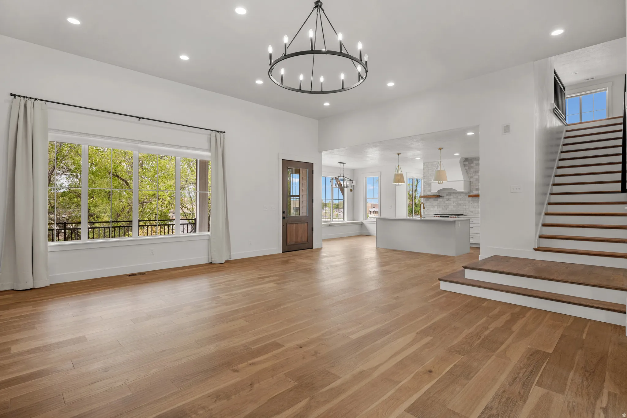 Unfurnished living room with a chandelier and light wood-type flooring