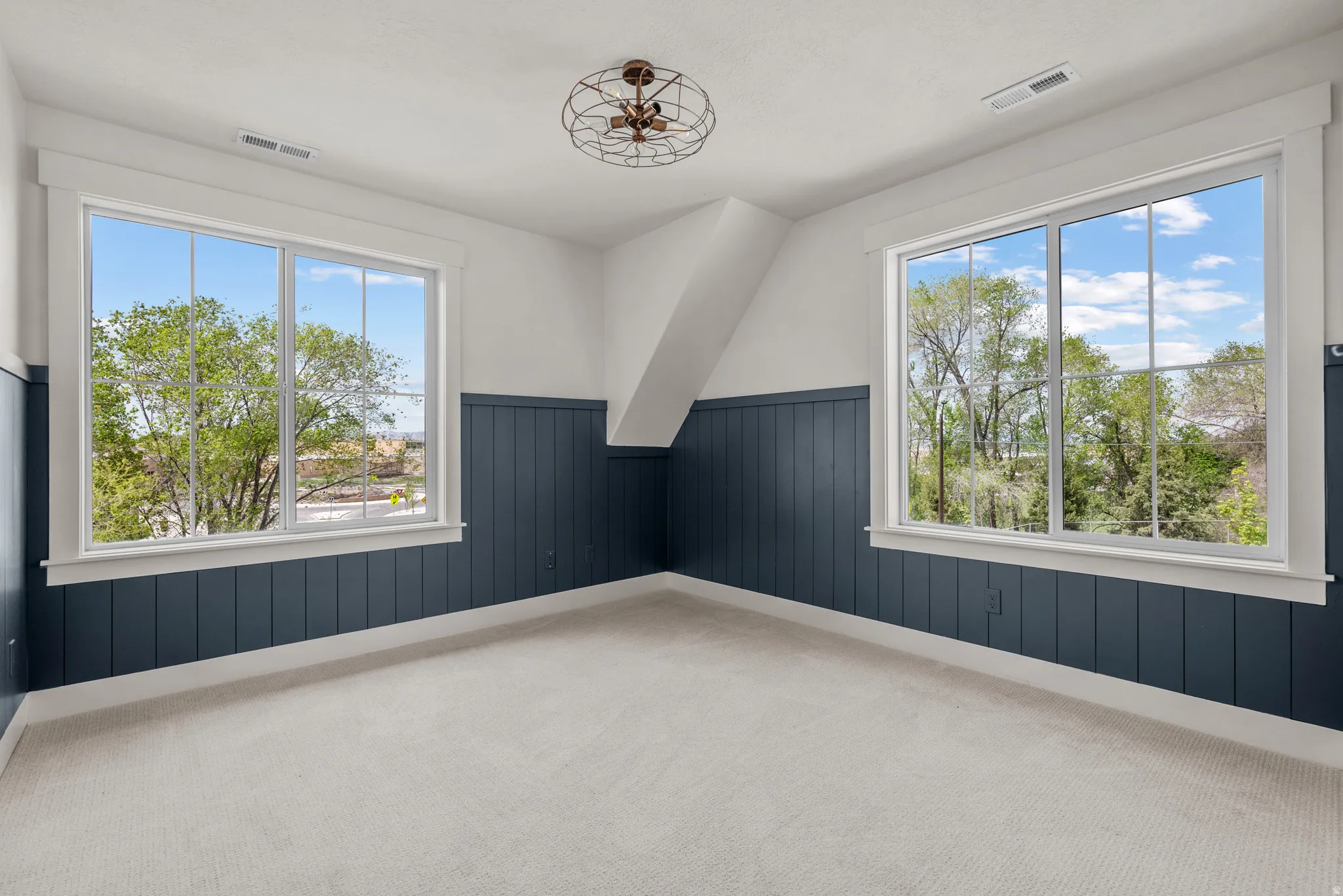Unfurnished room with a wainscoted wall, light carpet, and wood walls