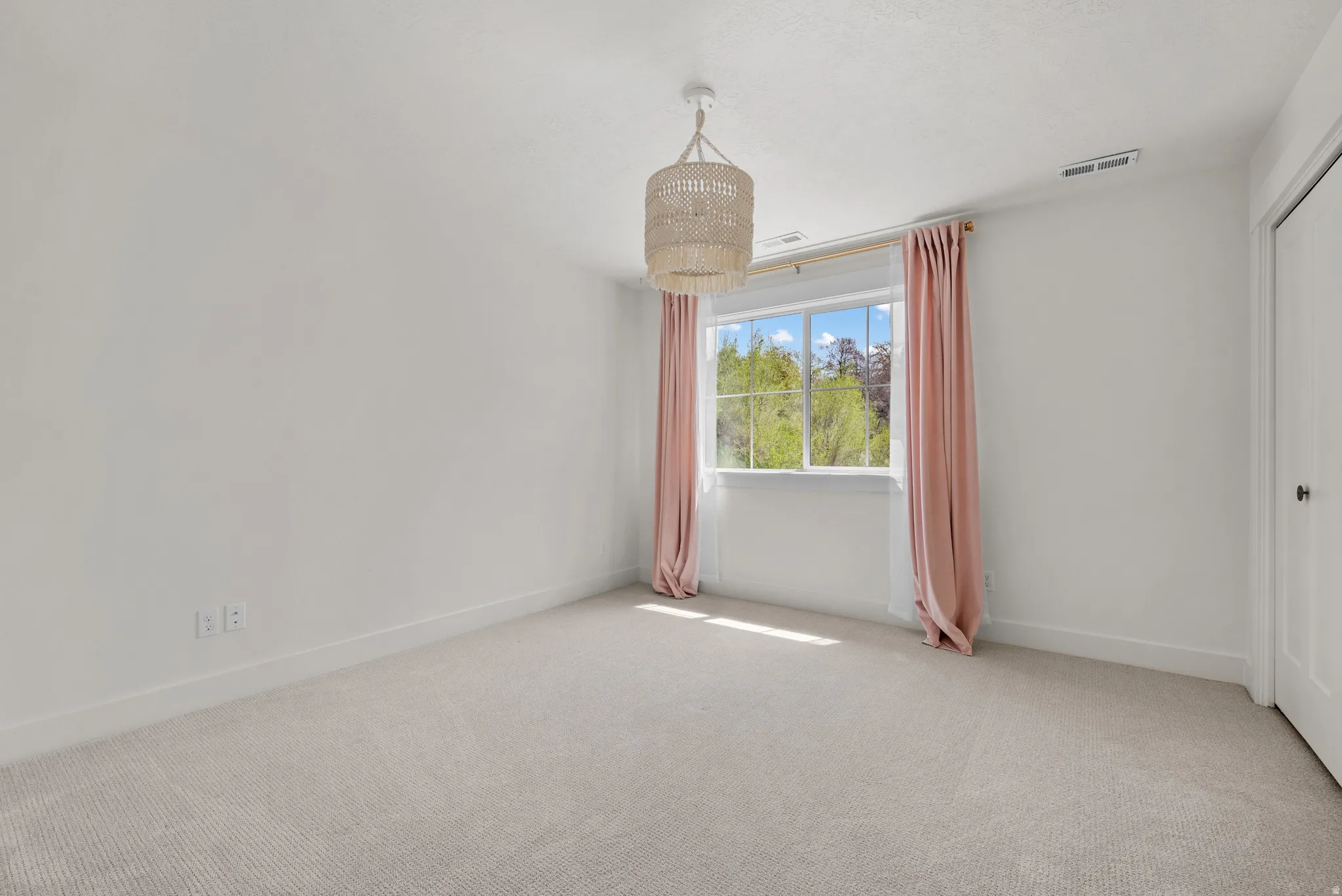 Empty room featuring carpet flooring and baseboards