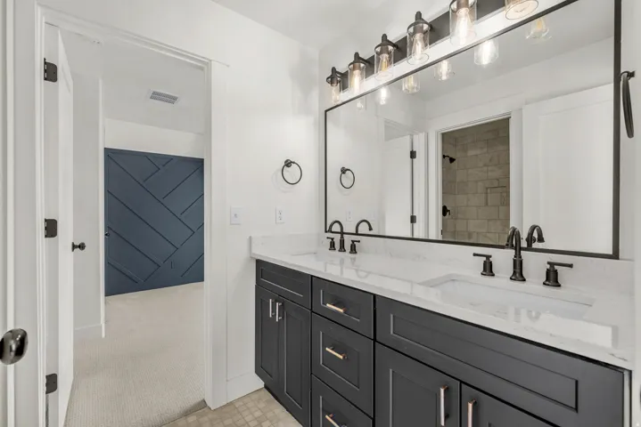 Full bathroom with double vanity and light carpet