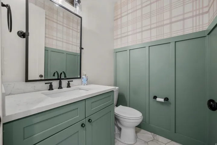 Bathroom featuring vanity, a decorative wall, and wallpapered walls