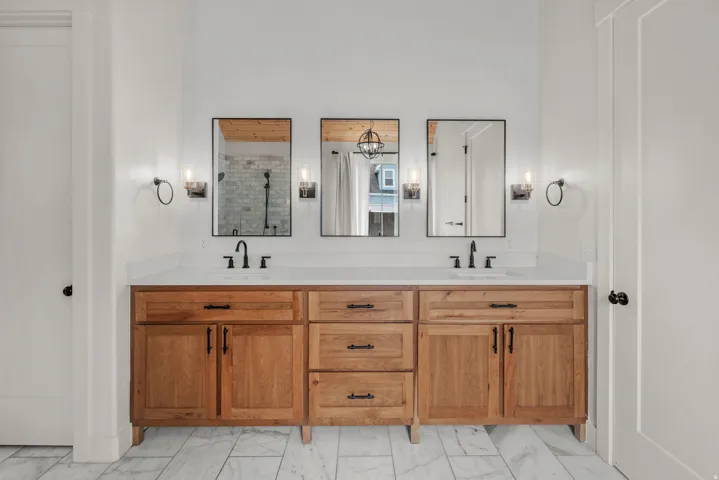 Full bath featuring double vanity and a stall shower