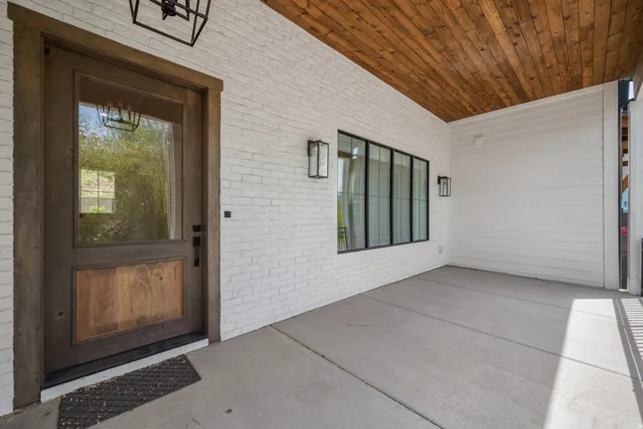Entrance to property with brick siding and a patio area