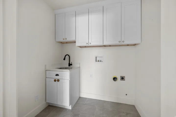 Laundry area featuring cabinet space, hookup for a washing machine, hookup for an electric dryer, and light tile patterned floors