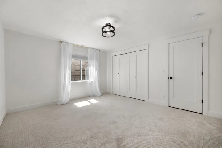 Unfurnished bedroom featuring carpet flooring, a textured ceiling, and a closet