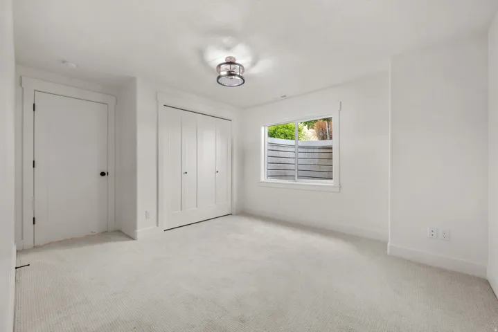 Unfurnished bedroom featuring light carpet and a closet