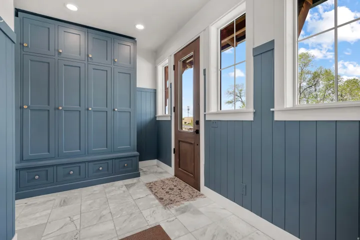 Entrance foyer featuring light marble finish floors, recessed lighting, and wood walls
