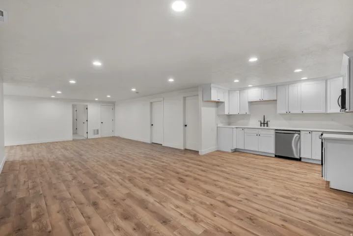Kitchen featuring light countertops, light wood finished floors, stainless steel appliances, recessed lighting, and open floor plan