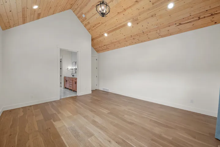 Bonus room with light wood-style floors, a high wooden ceiling, and hanging lights